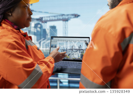 Close up of drilling rig engineering team using laptop software dashboard for anomaly detection during operation. Offshore platform coworkers use notebook program interface to control systems remotely Close up of drilling rig engineering team using laptop software dashboard for anomaly detection during operation. Offshore platform coworkers use notebook program interface to control systems remotely 135928349