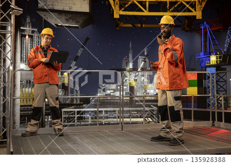 African american environmental engineer uses radio communication to inspect offshore drilling systems, ensuring efficient fuel production and compliance with oil and fuel extraction. African american environmental engineer uses radio communication to inspect offshore drilling systems, ensuring efficient fuel production and compliance with oil and fuel extraction. 135928388