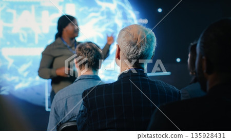 Senior investor listening to speaker presenting AI brain high tech with data visualization and deep learning demos. IT and business forum to obtain funding and investing at convention. Senior investor listening to speaker presenting AI brain high tech with data visualization and deep learning demos. IT and business forum to obtain funding and investing at convention. 135928431