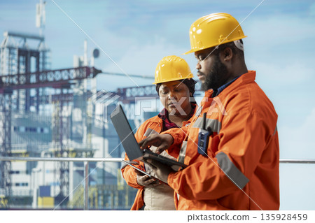 Team of environmental officers inspect offshore platform equipment for pollution control compliance. Drilling rig teamworking colleagues evaluate waste management systems to reduce ocean contamination 135928459