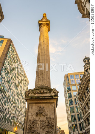 The Monument to the Great Fire of London rises above the surrounding buildings. This historic landmark commemorates the devastating fire that occurred in 1666, attracting visitors and locals alike. The Monument to the Great Fire of London rises above the surrounding buildings. This historic landmark commemorates the devastating fire that occurred in 1666, attracting visitors and locals alike. 135928997