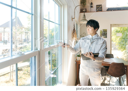 A man in work clothes inspecting indoor equipment A man in work clothes inspecting indoor equipment 135929364