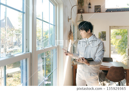 A man in work clothes inspecting indoor equipment A man in work clothes inspecting indoor equipment 135929365
