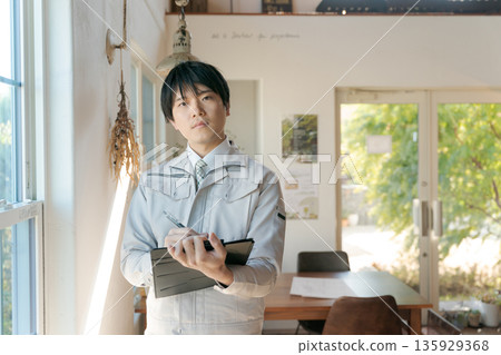 A man wearing work clothes 135929368