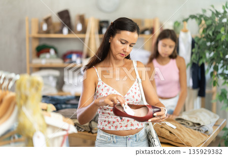 Woman shopping in clothing department, buying shoes 135929382
