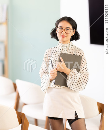 Portrait of female teacher with an electronic tablet in her hands Portrait of female teacher with an electronic tablet in her hands 135929523