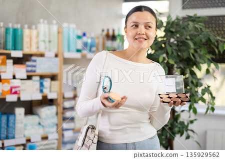 asian woman choosing cosmetics in a pharmacy asian woman choosing cosmetics in a pharmacy 135929562