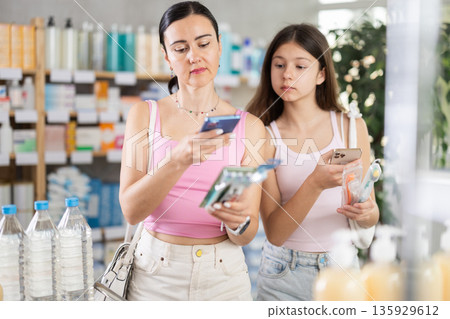 Mom and teen scan toothbrush packs 135929612