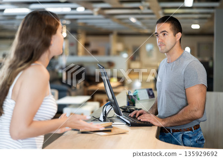 Male consultant helps a female customer choose materials for making furniture 135929692