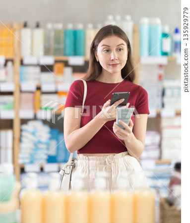 Woman scanning barcode of cream package Woman scanning barcode of cream package 135929779