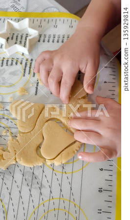 top view of children cutting gingerbread cookies from metal molds top view of children cutting gingerbread cookies from metal molds 135929814