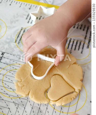 top view of children cutting gingerbread cookies from molds 135929830