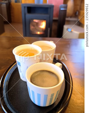 A cozy winter evening by the fireplace with warming drinks A cozy winter evening by the fireplace with warming drinks 135929912
