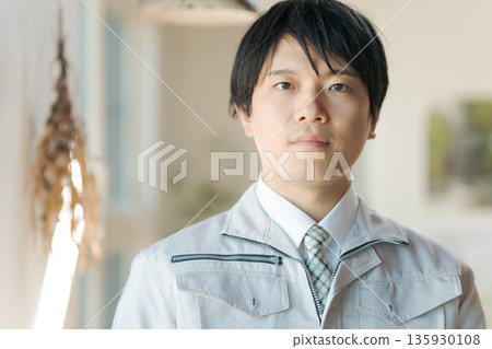 A young man wearing work clothes 135930108