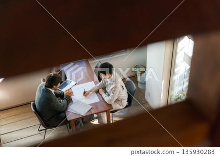 Two men looking at documents and having a meeting Two men looking at documents and having a meeting 135930283