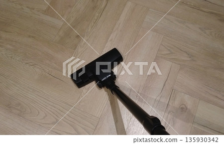 Vacuum cleaner floor nozzle on light wooden parquet, close-up 135930342