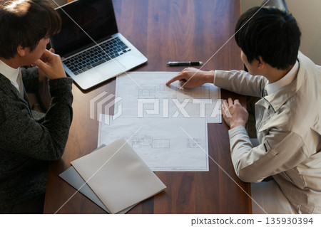 A man looking at a drawing and having a meeting A man looking at a drawing and having a meeting 135930394
