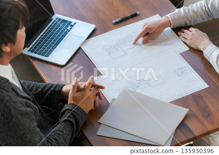 A man looking at a drawing and having a meeting A man looking at a drawing and having a meeting 135930396