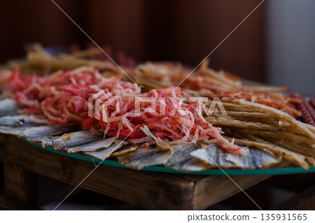 Freshly Sliced Pickled Vegetables and Dried Fish Arranged on a Wooden Platter with Vibrant Red and Golden Textures Freshly Sliced Pickled Vegetables and Dried Fish Arranged on a Wooden Platter with Vibrant Red and Golden Textures 135931565