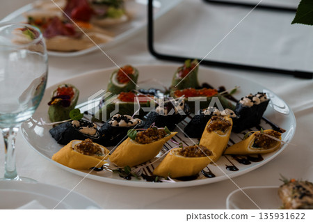 Artfully Arranged Sushi Rolls with Caviar and Herbs on White Plate, Elegant Japanese Cuisine Presentation Artfully Arranged Sushi Rolls with Caviar and Herbs on White Plate, Elegant Japanese Cuisine Presentation 135931622