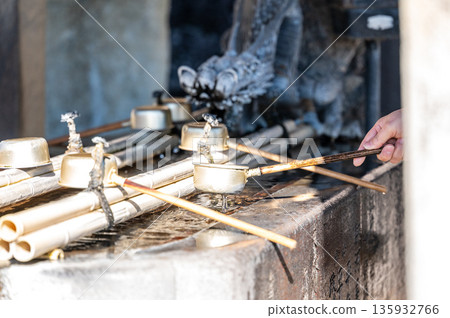 The traditional Japanese gesture of using a ladle at a water source 135932766