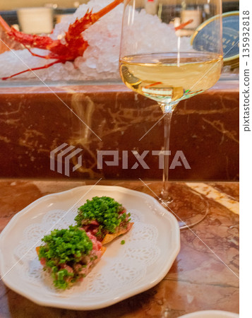 Meat tartare canapés topped with lots of leeks and white wine Meat tartare canapés topped with lots of leeks and white wine 135932818