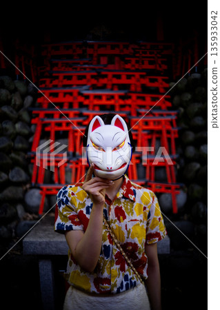 Portrait of a woman wearing a fox mask in the shrine grounds Portrait of a woman wearing a fox mask in the shrine grounds 135933042