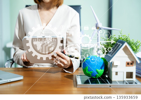 Eco businesswoman uses tablet with smart UI to analyze renewable energy, solar power, and smart home solutions. Green tech innovation meets sustainable data. 135933659