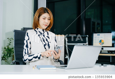 Business woman using tablet and laptop for doing math finance on an office desk, tax, report, accounting 135933904