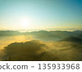 Aerial view of flowing fog waves on mountain tropical rainforest,Bird eye view image over the clouds Amazing nature background with clouds and mountain peaks in Thailand 135933968