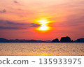 Golden sunset or sunrise over ocean horizon showing calm natural seascape waves sky background 135933975