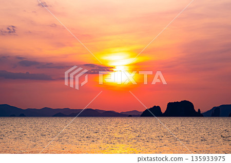 Golden sunset or sunrise over ocean horizon showing calm natural seascape waves sky background 135933975