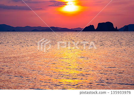 Golden sunset or sunrise over ocean horizon showing calm natural seascape waves sky background Golden sunset or sunrise over ocean horizon showing calm natural seascape waves sky background 135933976