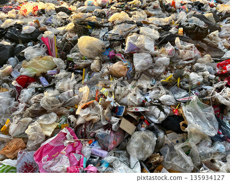Large pile of plastic waste and garbage bags at an open dumpsite, highlighting plastic pollution, environmental damage, waste management problems, recycling crisis, sustainability issues, and global e Large pile of plastic waste and garbage bags at an open dumpsite, highlighting plastic pollution, environmental damage, waste management problems, recycling crisis, sustainability issues, and global e 135934127