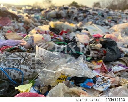 Large pile of plastic waste and garbage bags at an open dumpsite, highlighting plastic pollution, environmental damage, waste management problems, recycling crisis, sustainability issues, and global e Large pile of plastic waste and garbage bags at an open dumpsite, highlighting plastic pollution, environmental damage, waste management problems, recycling crisis, sustainability issues, and global e 135934130