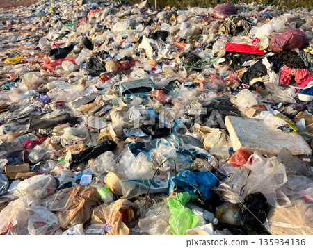 Large pile of plastic waste and garbage bags at an open dumpsite, highlighting plastic pollution, environmental damage, waste management problems, recycling crisis, sustainability issues, and global e Large pile of plastic waste and garbage bags at an open dumpsite, highlighting plastic pollution, environmental damage, waste management problems, recycling crisis, sustainability issues, and global e 135934136