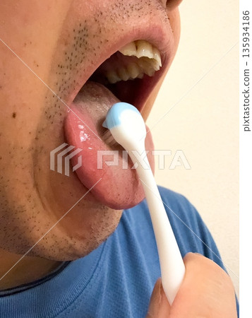 Man brushing his tongue 135934186