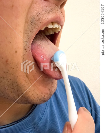 Man brushing his tongue 135934197