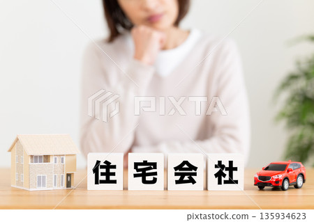 一位中年婦女擔心一家房屋公司的樓房。 135934623