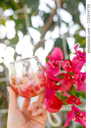 手中拿著三角梅、琉球玻璃杯 手中拿著三角梅、琉球玻璃杯 135934720