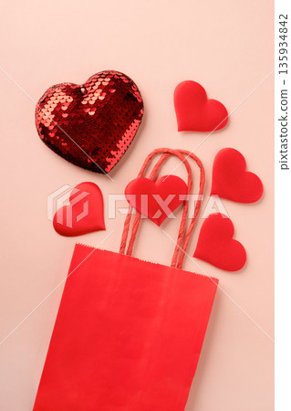 Red hearts spilling from shopping bag on pink background Red hearts spilling from shopping bag on pink background 135934842