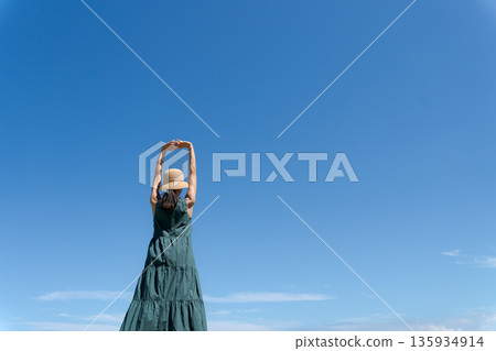 女子在海灘上伸展身體 135934914