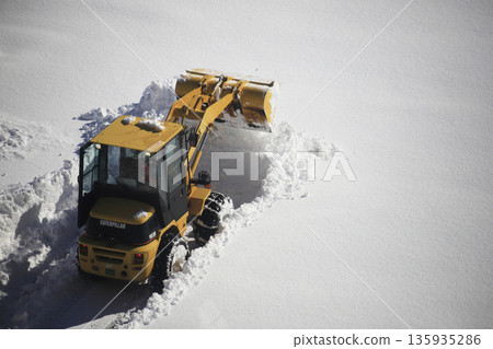 除雪車正在清理積雪覆蓋的停車場 135935286