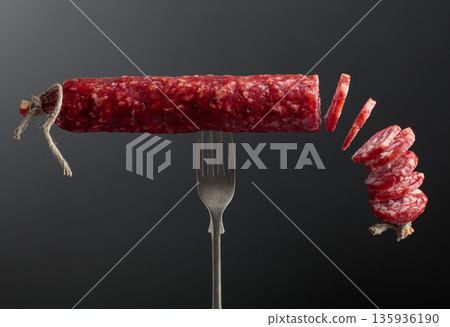 Dry cured sausage on a fork. 135936190