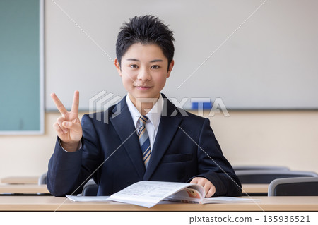 Male student making a peace sign 135936521