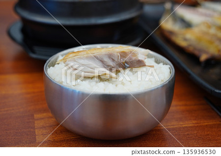 steamed white rice with a piece of grilled mackerel on top, a popular Korean home meal steamed white rice with a piece of grilled mackerel on top, a popular Korean home meal 135936530