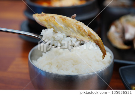 steamed white rice with a piece of grilled mackerel on top, a popular Korean home meal steamed white rice with a piece of grilled mackerel on top, a popular Korean home meal 135936531