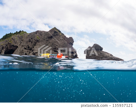 伊呂佐基港，海鳥觀光船半懸於水面之上，背景為白蘿蔔島。日本靜岡縣伊豆半島中木市南伊豆町平枝濱，郵編2025。 135937121