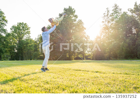Parenting outdoors. Happy father and toddler girl in park. Parenting outdoors. Happy father and toddler girl in park. 135937252