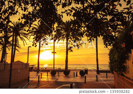 A deserted street leading to the embankment in the early morning during sunrise. Avenida de Benidorm, Sant Joan d'Alacant, Alicante, Spain A deserted street leading to the embankment in the early morning during sunrise. Avenida de Benidorm, Sant Joan d'Alacant, Alicante, Spain 135938282